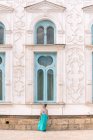 Lady in dress walking down steps outside shabby ornamental building on sunny day in Bukhara, Uzbekistan — Stock Photo