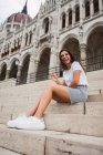Aktive lachende Frau sitzt auf Treppe eines antiken Gebäudes in Budapest — Stockfoto