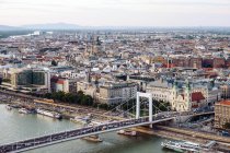 Boote auf dem Stadtkanal fließen unter Brücke in der hellen Tageszeit in Budapest — Stockfoto