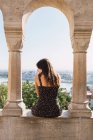 Woman sitting on columned marble fence in Budapest — Stock Photo