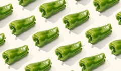 From above creative composition of sliced green whole pepper on white surface — Stock Photo