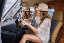 Les jeunes femmes regardant la carte à l'intérieur minivan — Photo de stock