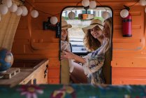 Cozy trailer and cheerful charming ladies looking in camera while riding — Stock Photo