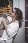 Vue latérale d'une femme calme câlinant un chien tout en se reposant ensemble à Marbella — Photo de stock