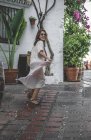 Vista laterale della donna entusiasta positiva alla moda con borsa estiva godendo passeggiando nel backstreet di Marbella — Foto stock