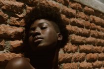 Молодая черная женщина с закрытыми глазами у стены — стоковое фото