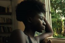Donna nera appoggiata a una finestra — Foto stock