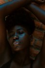 Молодая черная женщина с закрытыми глазами у стены — стоковое фото