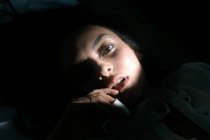 Чудова чуттєва жінка лежить у темряві — стокове фото