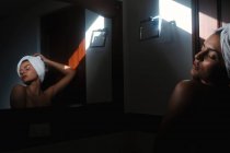 Serene sensuelle femme nue contre miroir dans la salle de bain — Photo de stock