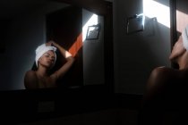 Serene sensual naked woman against mirror in bathroom — Stock Photo