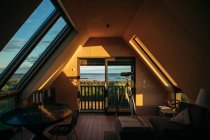 Небольшая уютная комната с оконным телескопом для наблюдения за звездами и удивительным пейзажем в солнечный день в Исландии — стоковое фото