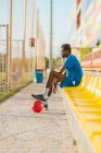 Сторона зору афроамериканського футболіста, що відпочиває на сидіннях стадіону — стокове фото