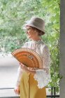 Женщина с ретро-вентилятором в парке — стоковое фото