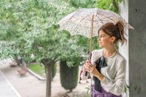 Вінтажна дама з парасолькою відпочиває в саду — стокове фото