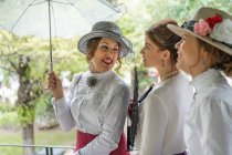 Vintage femminile apertura ombrellone vicino amici — Foto stock