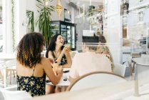 Divers amis au repos avec des smoothies assis dans un café — Photo de stock