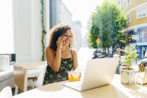 Frau mit Laptop genießt gesundes Getränk im Café — Stockfoto