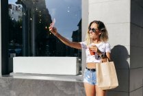 Mulher alegre tomando selfie como deixando restaurante — Fotografia de Stock