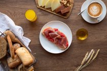 Сверху вкусные испанские тосты с помидорами и беконом на завтрак на деревянном столе — стоковое фото