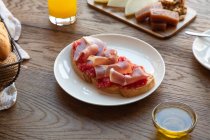 Сверху вкусные испанские тосты с помидорами и беконом на завтрак на деревянном столе — стоковое фото