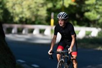 Professional cyclist riding bike in park — Stock Photo