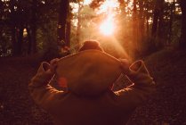 Persona che guarda il tramonto nella foresta autunnale — Foto stock