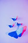 Pink and blue butterflies attached to lilac wall — Stock Photo