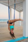 Relaxed woman performing aerial yoga hanging head down — Stock Photo