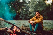 Wanderin wärmt Hände am Lagerfeuer auf Waldlichtung — Stockfoto