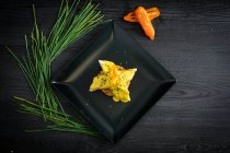 Корвина с желтым перцовым соусом в черной тарелке — стоковое фото