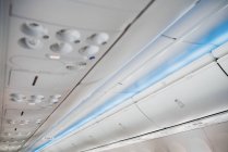 Weißes Flugzeug-Deckenfach mit verschiedenen Knöpfen — Stockfoto