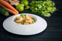Sabroso Pad Thai de verduras y gambas en plato blanco - foto de stock