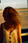 Curly mulher encantadora sorrindo enquanto caminhava na sala vítrea luz do aeroporto no Texas — Fotografia de Stock