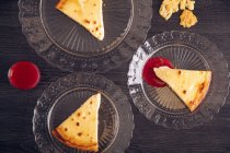 Von oben leckere Käsekuchenstücke mit appetitanregender Himbeermarmelade in Zierglasplatten — Stockfoto