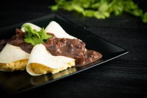 Huevos de veracruz envueltos en tortillas decoradas con salsa - foto de stock