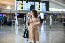 Жінка використовує смартфон в аеропорту — стокове фото