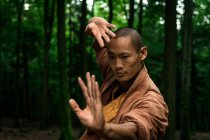 Homem étnico praticando artes marciais na floresta — Fotografia de Stock