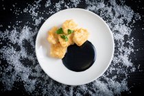 Nasello impanato con crema di calamari in piatto — Foto stock