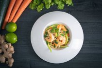 Sabroso Pad Thai de verduras y gambas en plato blanco - foto de stock