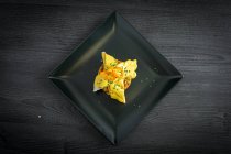 Корвіна з жовтим перцевим соусом в чорній тарілці — стокове фото