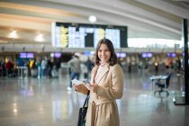 Mujer usando smartphone en el aeropuerto - foto de stock