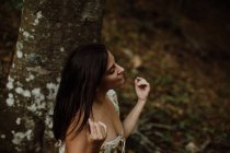 Сором'язлива чуттєва жінка сидить на камені в лісі — стокове фото