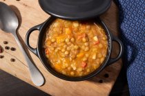 Sopa de lentilha tradicional espanhola com legumes em panela de caçarola preta na mesa . — Fotografia de Stock