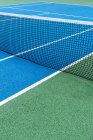 Detail des blauen und grünen Tennisplatzes mit schwarzem Netz. — Stockfoto