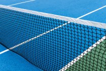 Dettaglio campo da tennis esterno blu e verde con rete nera . — Foto stock