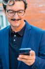 Senior businessman in blue jacket using smartphone — Stock Photo