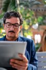 Alter gutaussehender Mann nutzt digitales Tablet im Freien — Stockfoto