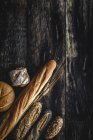 Плоский шар золотого асортименту домашнього хліба на темному дерев'яному фоні — стокове фото