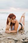 Ginger woman relaxing on beach during sunset — Stock Photo